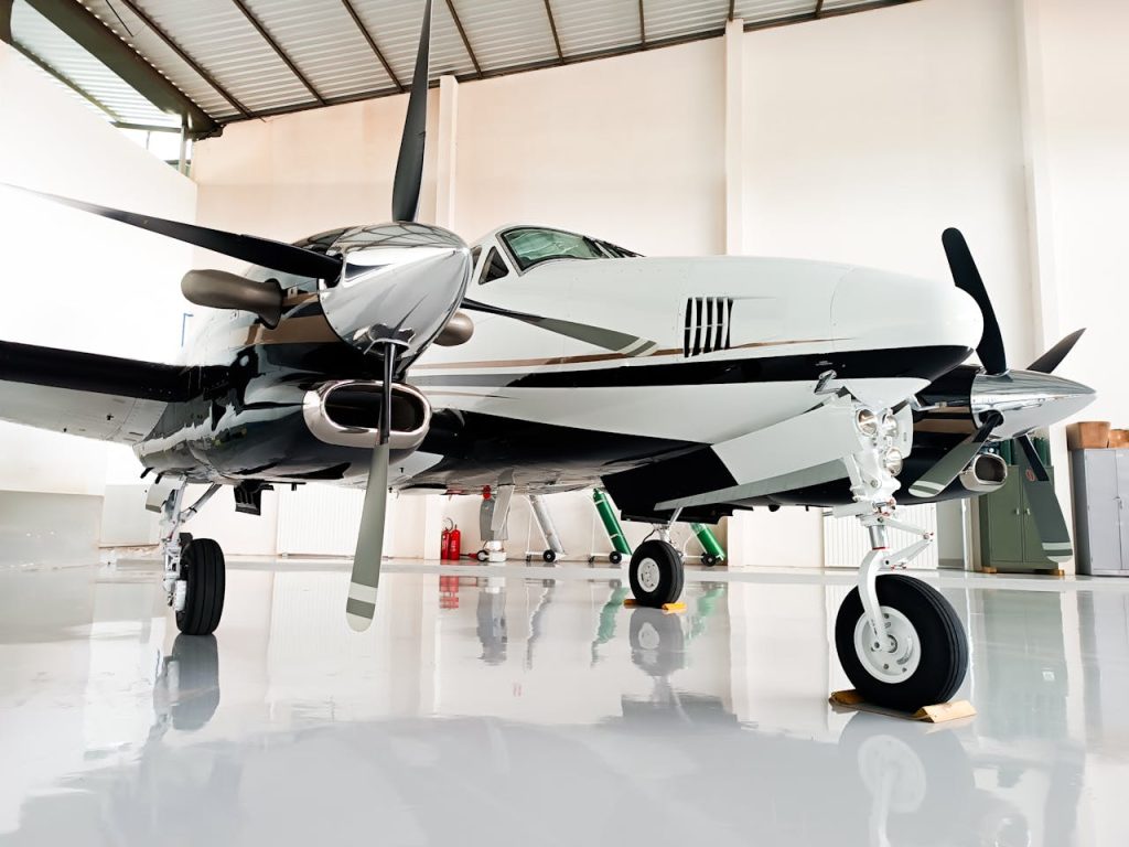 Sleek private airplane with chrome details in a bright, clean hangar.